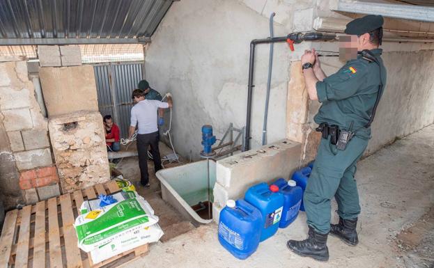 Un agente de la Guardia Civil fotografía las instalaciones de una de las desaladoras investigadas en la pedanía pachequera de Balsicas, este martes.