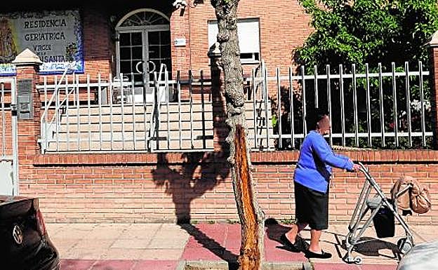 Una anciana pasa junto a la puerta de la residencia Virgen de la Fuensanta, ayer en Murcia. 
