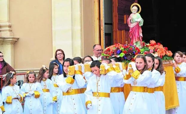 Un grupo de niños sale de la iglesia con el paso de San Pedro. 