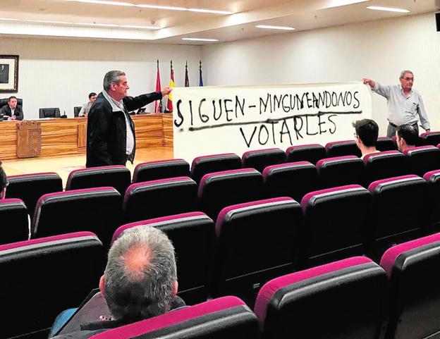 Dos pensionistas despliegan la pancarta, en el último Pleno. 