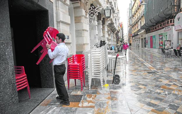 Un camarero retira sillas de la terraza de un bar de la calle Mayor, el pasado domingo. 