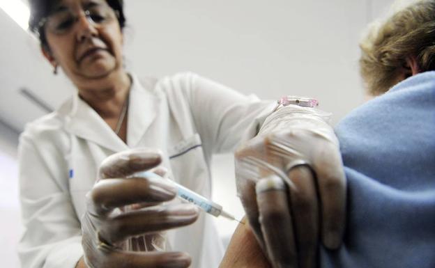Una mujer recibe la vacuna contra la gripe.