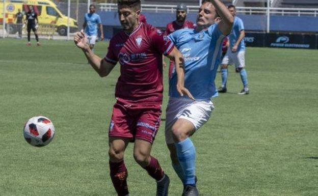 Peke, jugador vinícola, disputa un balón con un futbolista de la UD Ibiza.