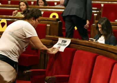 Imagen secundaria 1 - Arrimadas porta una bandera de España en el Parlament (Arriba); La diputada de la CUP, Natalia Sánchez , coloca un cartel con el lema «Stop Fascim» ante la líder de Ciudadanos (izq.); Arrimadas interpela al presidente de la Generalitat, Quim Torra, durante la sesión de control al Govern (dcha.). 