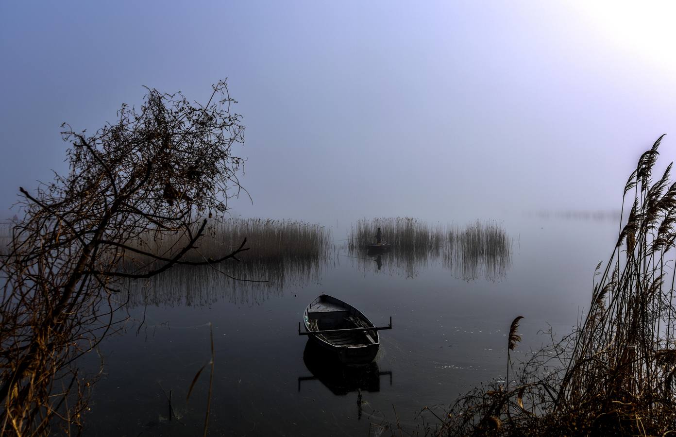 Varias personas pescan bajo la niebla en las orillas del lago Dojran, Macedonia. El lago Dojran es una reserva natural que atrae a diferentes especies de aves debido al clima relativamente cálido y la gran cantidad de peces.