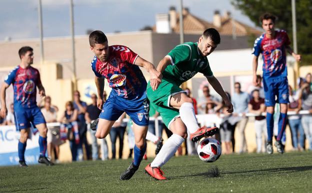 Un jugador del Churra se lleva el balón, acosado por un rival.