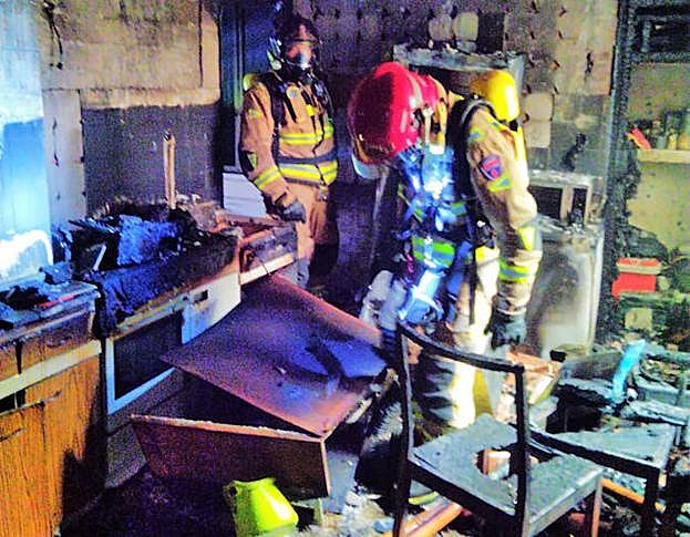 Dos bomberos trabajan para apagar el incendio en la vivienda de Yecla.