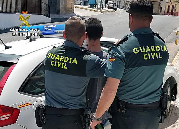 Dos agentes de la Guardia Civil conducen al detenido.