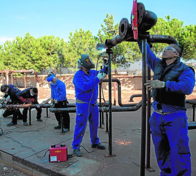 Cuatro alumnos del curso de tubero industrial del Instituto Politécnico, en una clase práctica. 