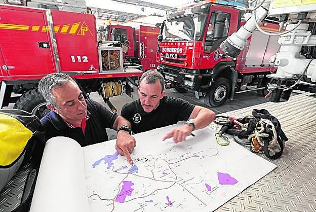 Salvador Pérez y Toni Ros consultan un plano con sendas, en el Parque de Bomberos. 