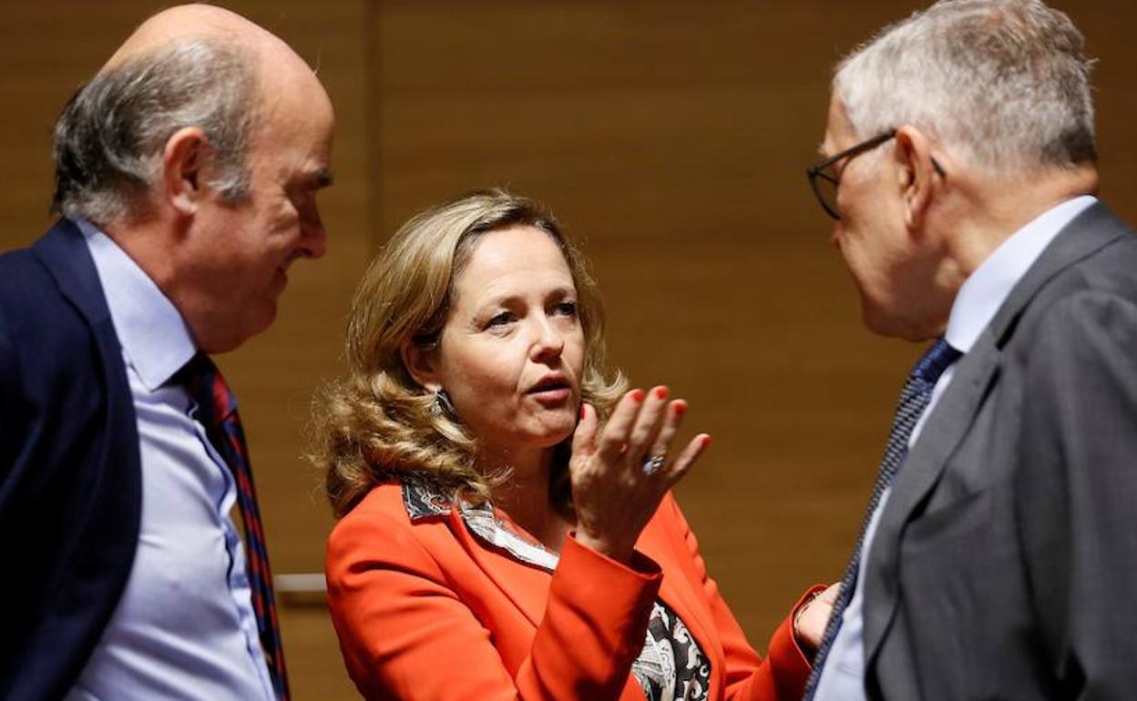 Nadia Calviño (c), conversa con el vicepresidente del Banco Central Europeo, Luis de Guindos (i), y el director gerente del Mecanismo Europeo de Estabilidad, Klaus Regling. 