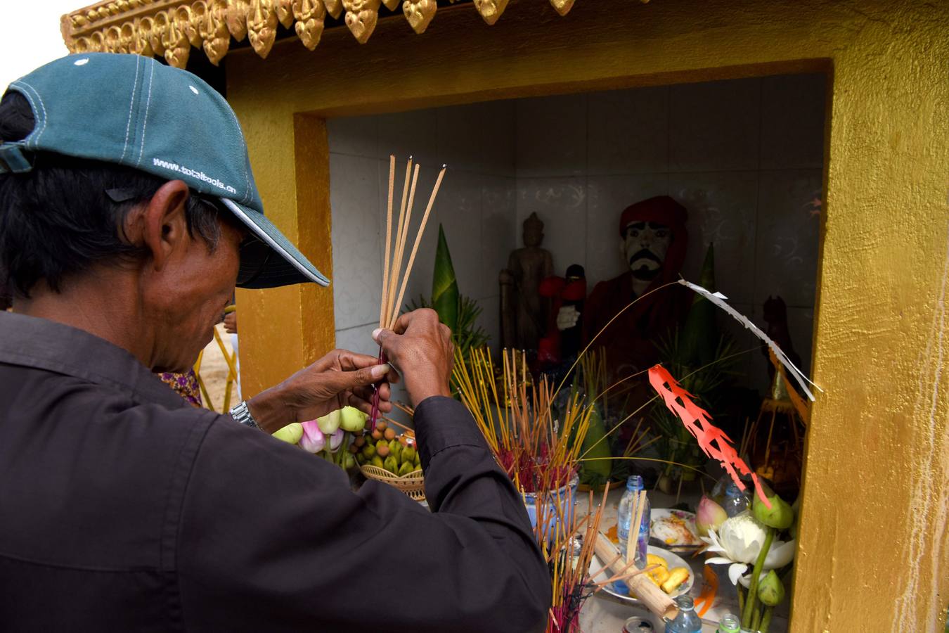 Varias personas participan en la ceremonia que honra la memoria de los espíritus del hogar de la aldea Pring Ka-Ek, este viernes en Nom Pen (Camboya). Los residentes buscan prevenir enfermedades y potenciar las cosechas a través de estos rituales milenarios.