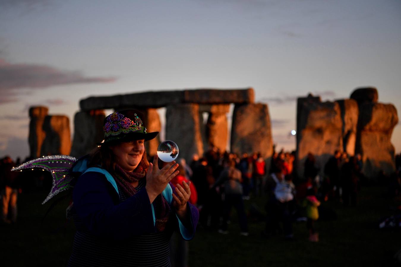 Varios entusiastas reciben el amanecer mientras participan en las celebraciones por el solsticio de verano en Stonehenge, en Wiltshire (Reino Unido). Este festival atrae anualmente a cientos de personas para celebrar el llegada del día más largo en el hemisferio norte.