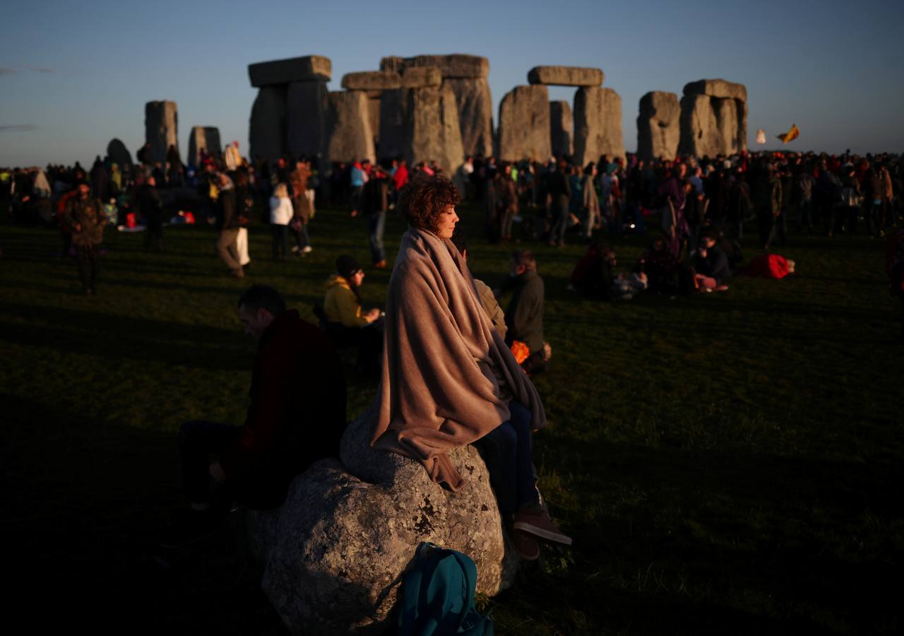 Varios entusiastas reciben el amanecer mientras participan en las celebraciones por el solsticio de verano en Stonehenge, en Wiltshire (Reino Unido). Este festival atrae anualmente a cientos de personas para celebrar el llegada del día más largo en el hemisferio norte.