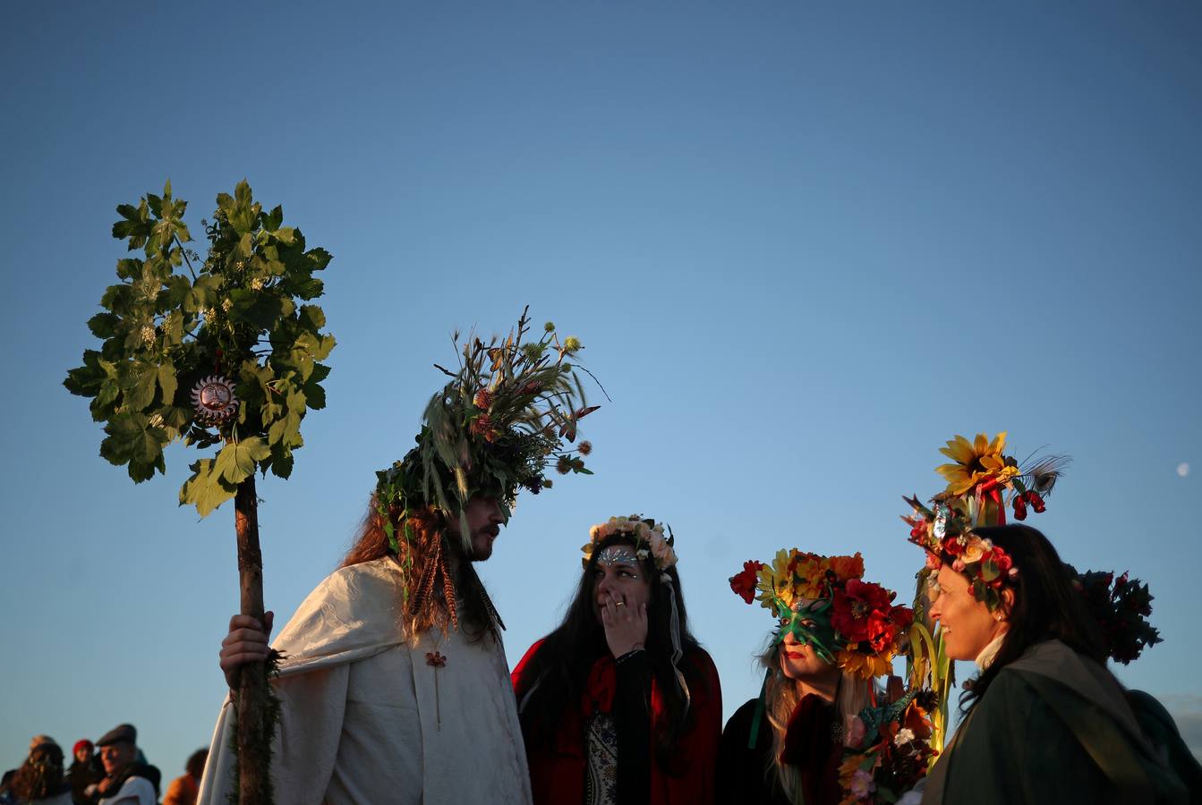 Varios entusiastas reciben el amanecer mientras participan en las celebraciones por el solsticio de verano en Stonehenge, en Wiltshire (Reino Unido). Este festival atrae anualmente a cientos de personas para celebrar el llegada del día más largo en el hemisferio norte.