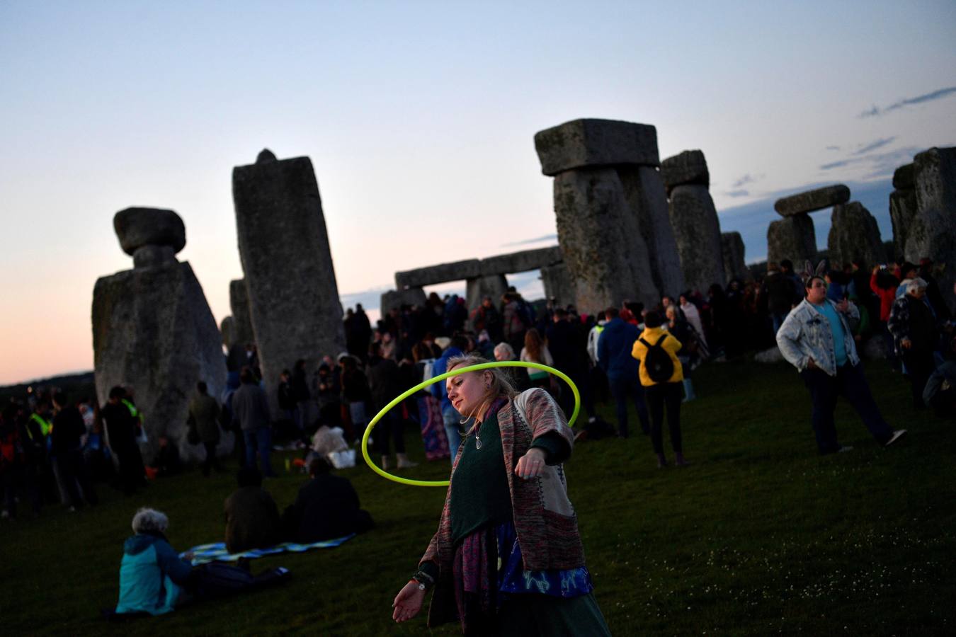 Varios entusiastas reciben el amanecer mientras participan en las celebraciones por el solsticio de verano en Stonehenge, en Wiltshire (Reino Unido). Este festival atrae anualmente a cientos de personas para celebrar el llegada del día más largo en el hemisferio norte.