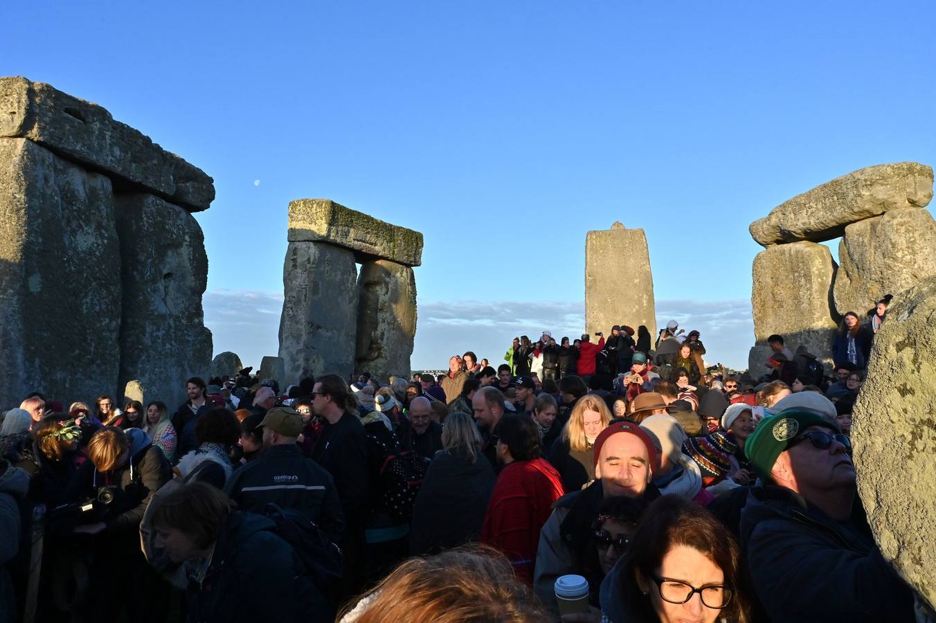 Varios entusiastas reciben el amanecer mientras participan en las celebraciones por el solsticio de verano en Stonehenge, en Wiltshire (Reino Unido). Este festival atrae anualmente a cientos de personas para celebrar el llegada del día más largo en el hemisferio norte.