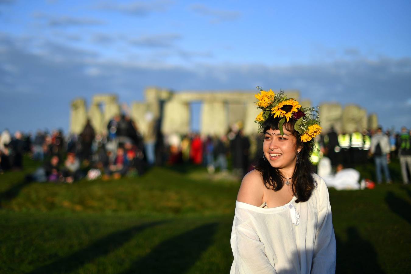 Varios entusiastas reciben el amanecer mientras participan en las celebraciones por el solsticio de verano en Stonehenge, en Wiltshire (Reino Unido). Este festival atrae anualmente a cientos de personas para celebrar el llegada del día más largo en el hemisferio norte.