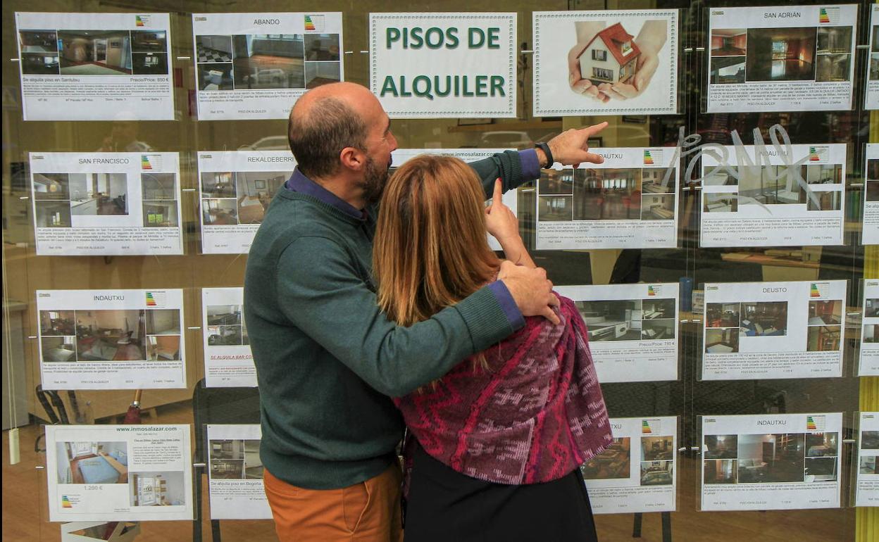 Una pareja busca ofertas de pisos en alquiler.