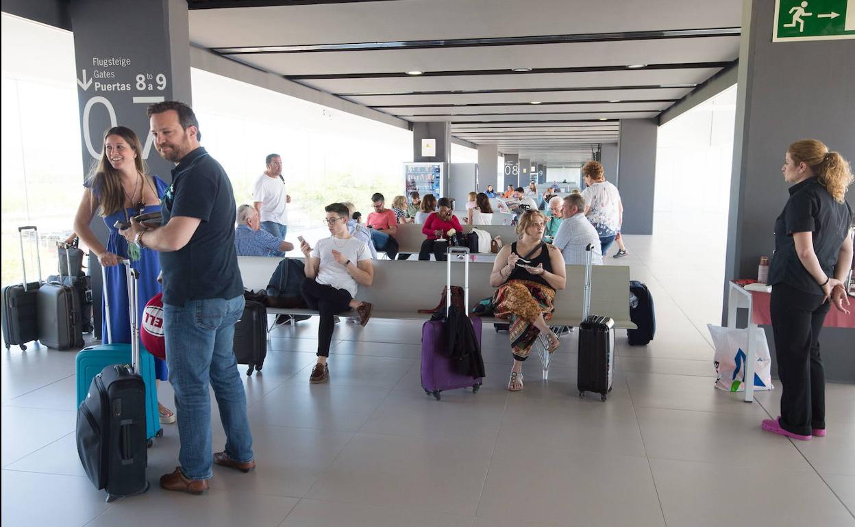 Varios pasajeros aguardan su vuelo en el aeropuerto de Corvera. 