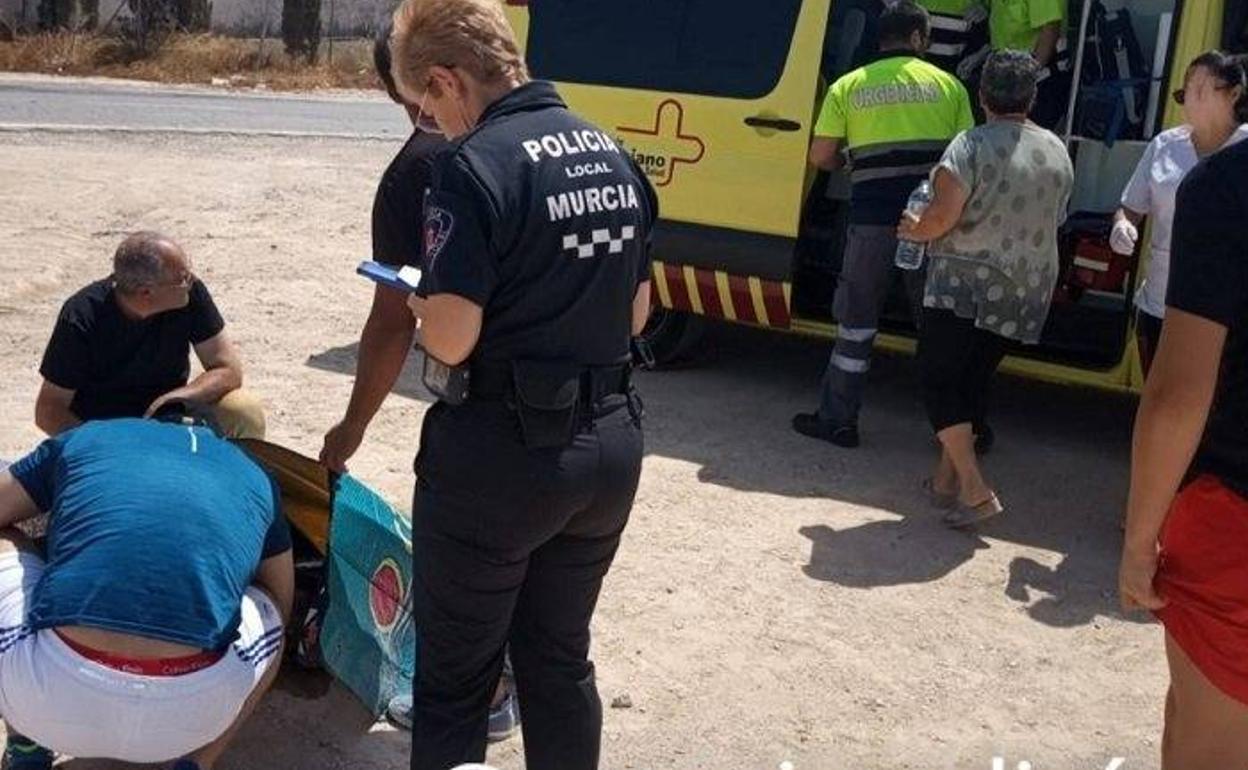 Los servicios sanitarios y agentes de la Policía Local de Murcia atienden al herido en el lugar del siniestro. 