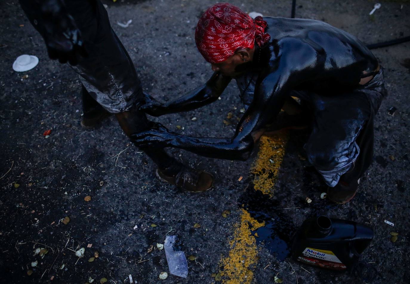 Varias personas llevan el cuerpo cubierto con aceite para cumplir con la tradición de «Los Diablitos Negros» durante una procesión en la que fieles católicos transportan la imagen de Santo Domingo de Guzmán, en Managua (Nicaragua). Como es tradición, la música pone el tono festivo y los creyentes bailan a la vez que avanzan hacia el norte de Managua, alrededor de la imagen, que es zangoloteada por los cargadores, como símbolo de alegría.