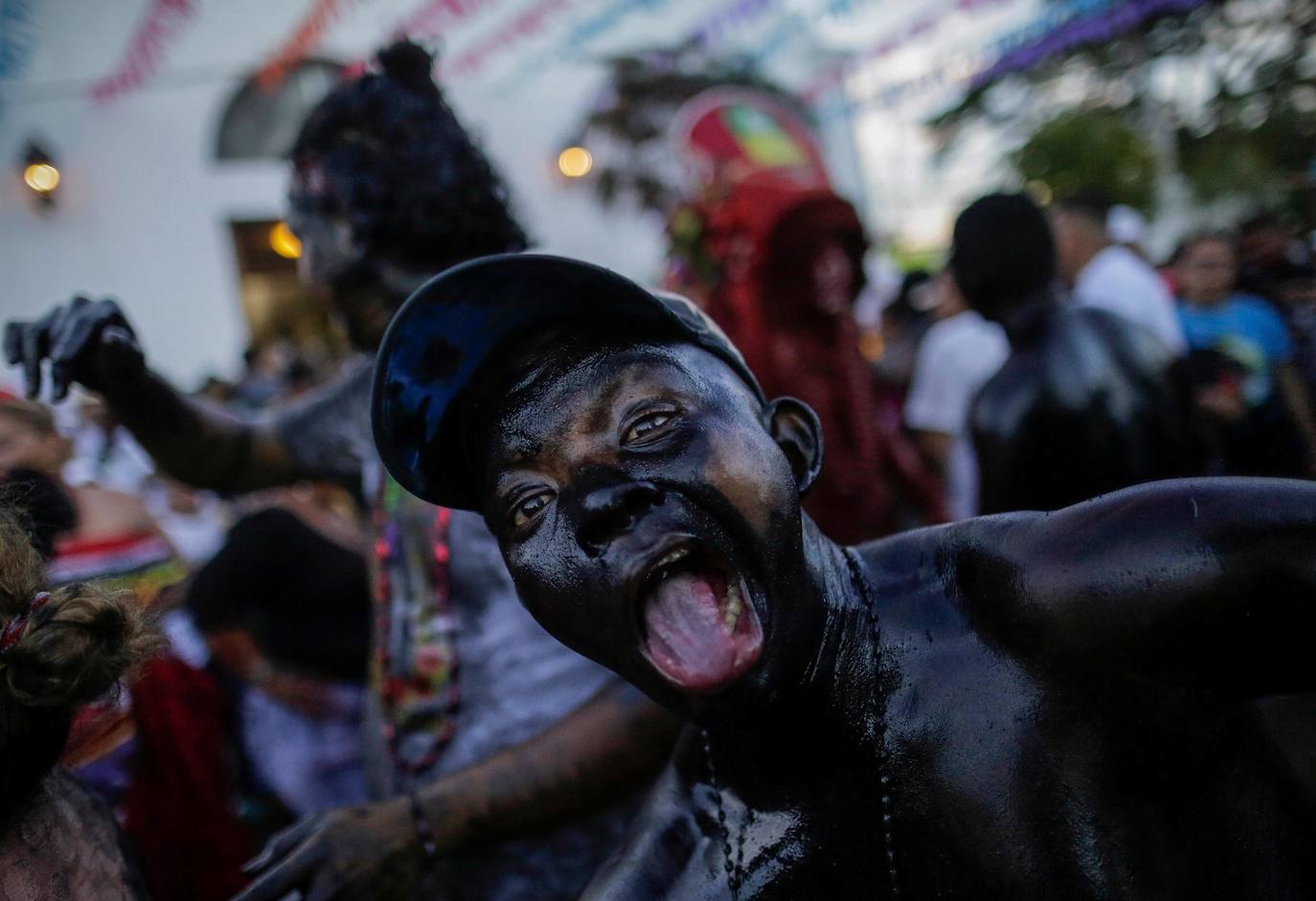 Varias personas llevan el cuerpo cubierto con aceite para cumplir con la tradición de «Los Diablitos Negros» durante una procesión en la que fieles católicos transportan la imagen de Santo Domingo de Guzmán, en Managua (Nicaragua). Como es tradición, la música pone el tono festivo y los creyentes bailan a la vez que avanzan hacia el norte de Managua, alrededor de la imagen, que es zangoloteada por los cargadores, como símbolo de alegría.
