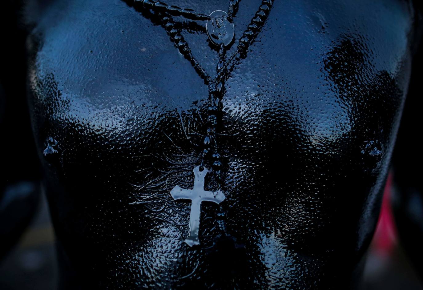 Varias personas llevan el cuerpo cubierto con aceite para cumplir con la tradición de «Los Diablitos Negros» durante una procesión en la que fieles católicos transportan la imagen de Santo Domingo de Guzmán, en Managua (Nicaragua). Como es tradición, la música pone el tono festivo y los creyentes bailan a la vez que avanzan hacia el norte de Managua, alrededor de la imagen, que es zangoloteada por los cargadores, como símbolo de alegría.