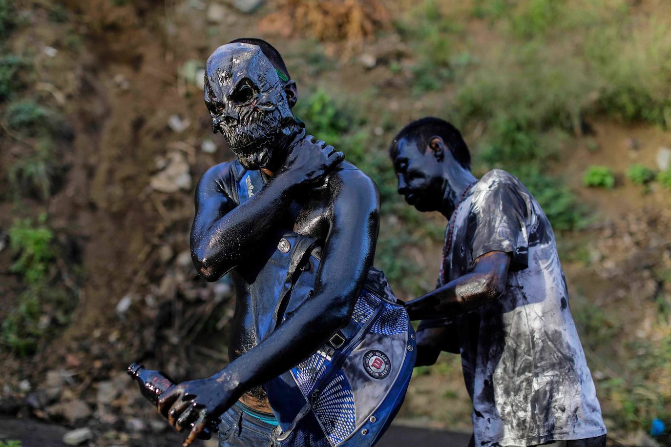 Varias personas llevan el cuerpo cubierto con aceite para cumplir con la tradición de «Los Diablitos Negros» durante una procesión en la que fieles católicos transportan la imagen de Santo Domingo de Guzmán, en Managua (Nicaragua). Como es tradición, la música pone el tono festivo y los creyentes bailan a la vez que avanzan hacia el norte de Managua, alrededor de la imagen, que es zangoloteada por los cargadores, como símbolo de alegría.