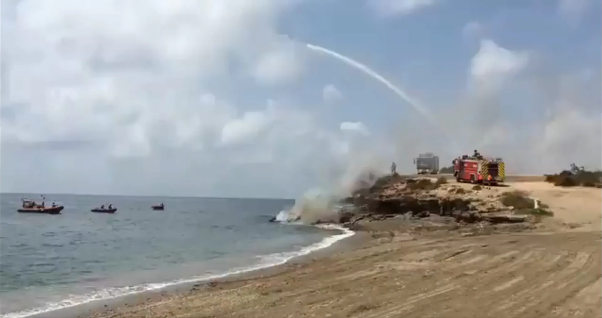 Los bomberos extinguen el incendio declarado este viernes en un barco, en las inmediaciones del puerto Juan Montiel.