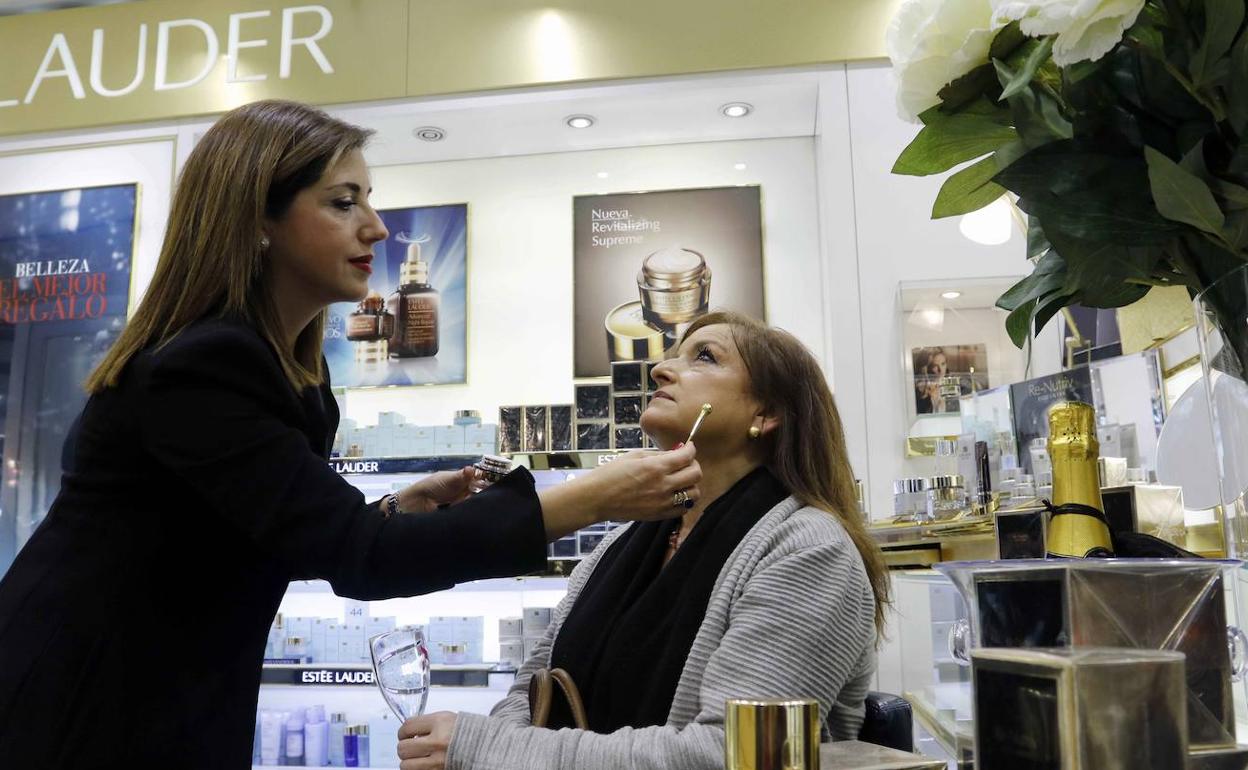 Un empleada de un comercio de Murcia maquilla a una clienta, en una foto de archivo.