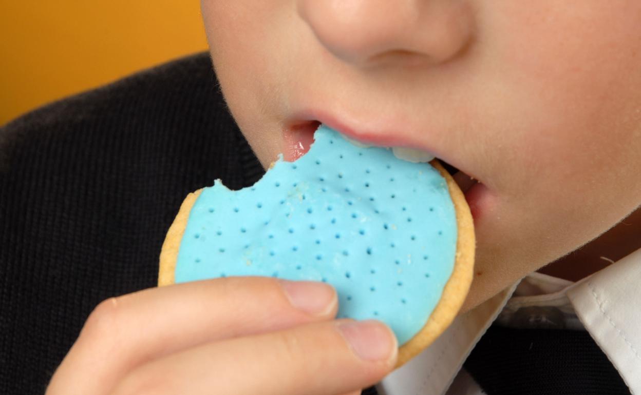 Un niño muerde una galleta. 