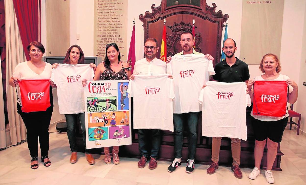 El alcalde y el concejal de Festejos, junto con los organizadores, posan con la camiseta y el cartel. 