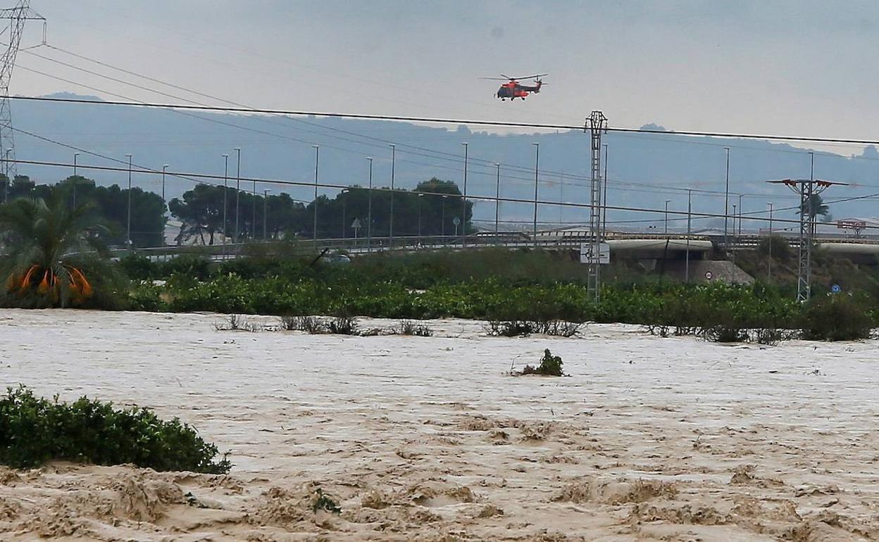 Un helicóptero de rescate sobrevuela una zona inundada de Orihuela.