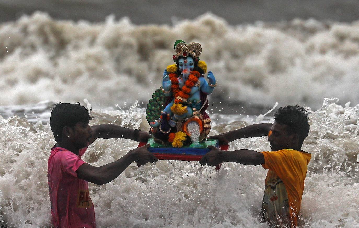 Indios devotos emergen en el mar Arábigo al dios con cabeza de elefante Ganesha durante la celebración del festival Ganesh Chaturthi, en Bombay (India). Esta celebración tiene lugar el cuarto día de la primera quincena del mes hindú Bhaadrapa, una jornada que coincide con el aniversario del nacimiento de Ganesha, hijo de Shiva y Parvati.