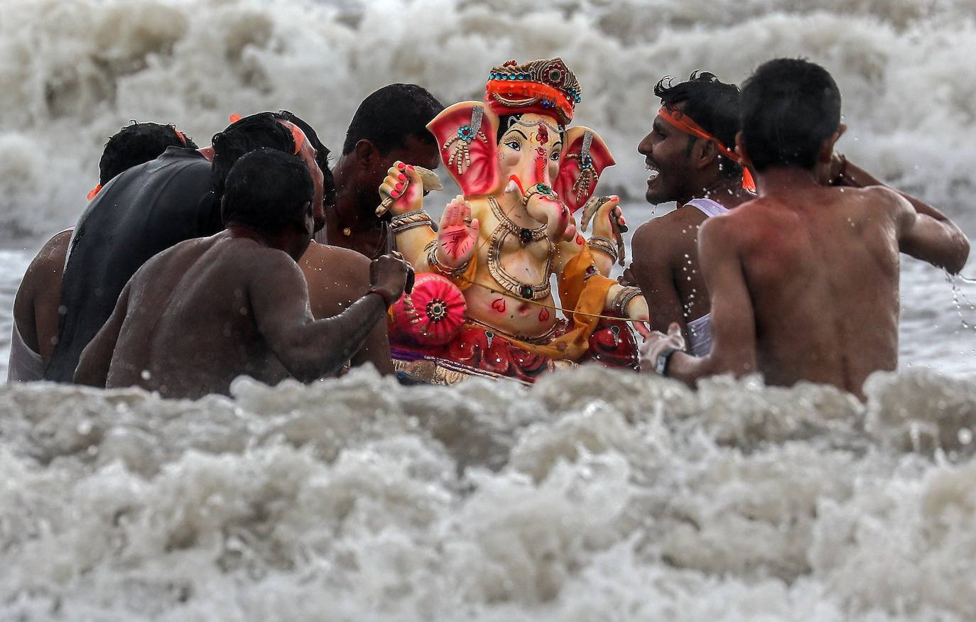 Indios devotos emergen en el mar Arábigo al dios con cabeza de elefante Ganesha durante la celebración del festival Ganesh Chaturthi, en Bombay (India). Esta celebración tiene lugar el cuarto día de la primera quincena del mes hindú Bhaadrapa, una jornada que coincide con el aniversario del nacimiento de Ganesha, hijo de Shiva y Parvati.