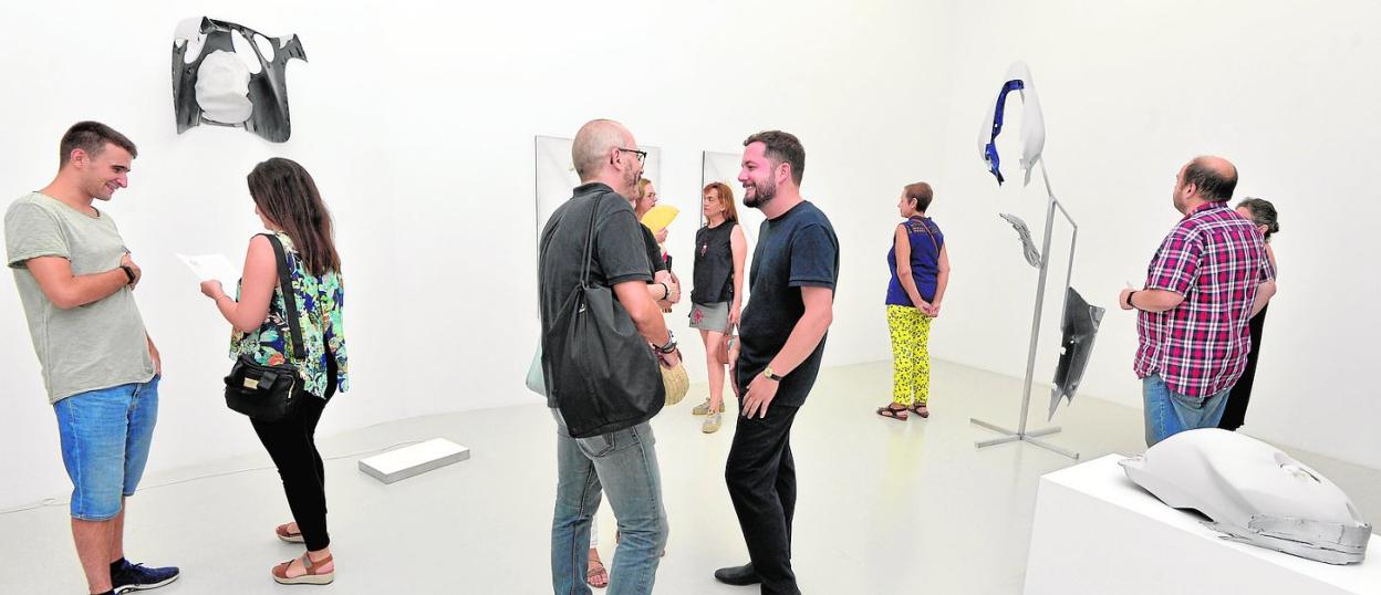 Sergio Porlán, en el centro, con varias de las piezas que pueden verse en la galería, el día de la inauguración. 