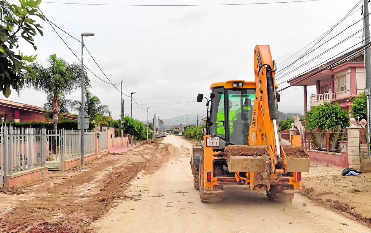 Un tractor, ayer, mientras retiraba barro en una calle de la localidad. 
