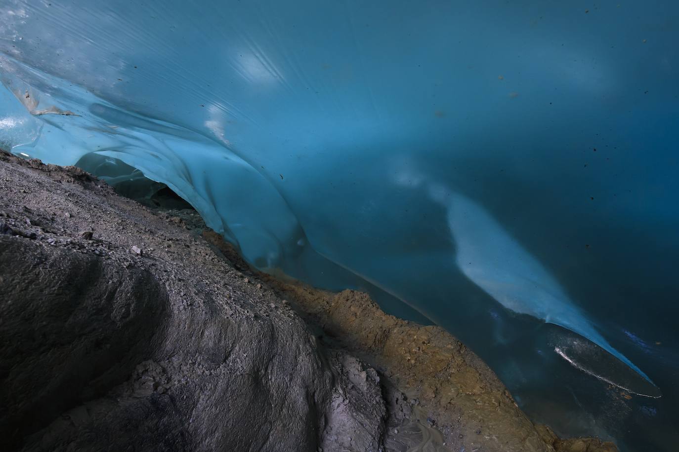 Un hombre mira el glaciar Aletsch desde una cavidad interior, en el Cantón de Valais (Suiza). El glaciar suizo Aletsch es uno más grandes de Europa y el primer lugar de los Alpes declarado Patrimonio de la Humanidad por la Unesco. Este enorme río de hielo se extiende a lo largo de 23 km desde su formación en la región de Jungfrau hasta el desfiladero de Massa, en el Cantón del Valais.
