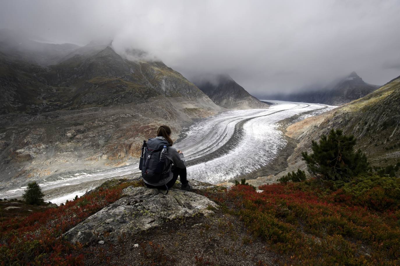 Un hombre mira el glaciar Aletsch desde una cavidad interior, en el Cantón de Valais (Suiza). El glaciar suizo Aletsch es uno más grandes de Europa y el primer lugar de los Alpes declarado Patrimonio de la Humanidad por la Unesco. Este enorme río de hielo se extiende a lo largo de 23 km desde su formación en la región de Jungfrau hasta el desfiladero de Massa, en el Cantón del Valais.