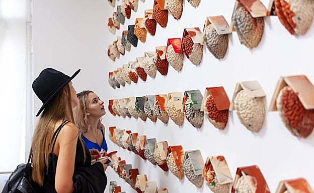 Imagen principal - Dos visitantes observan las piezas mostradas hasta el 4 de noviembre. | Lidó Rico, junto a una de sus creaciones. | Una de las obras expuestas más inquietantes. 