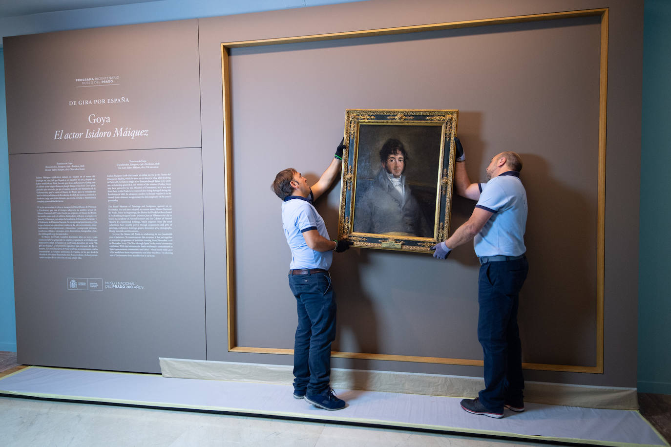 Dos técnicos cuelgan el retrato de Isidoro Máiquez, esta mañana en el Mubam.