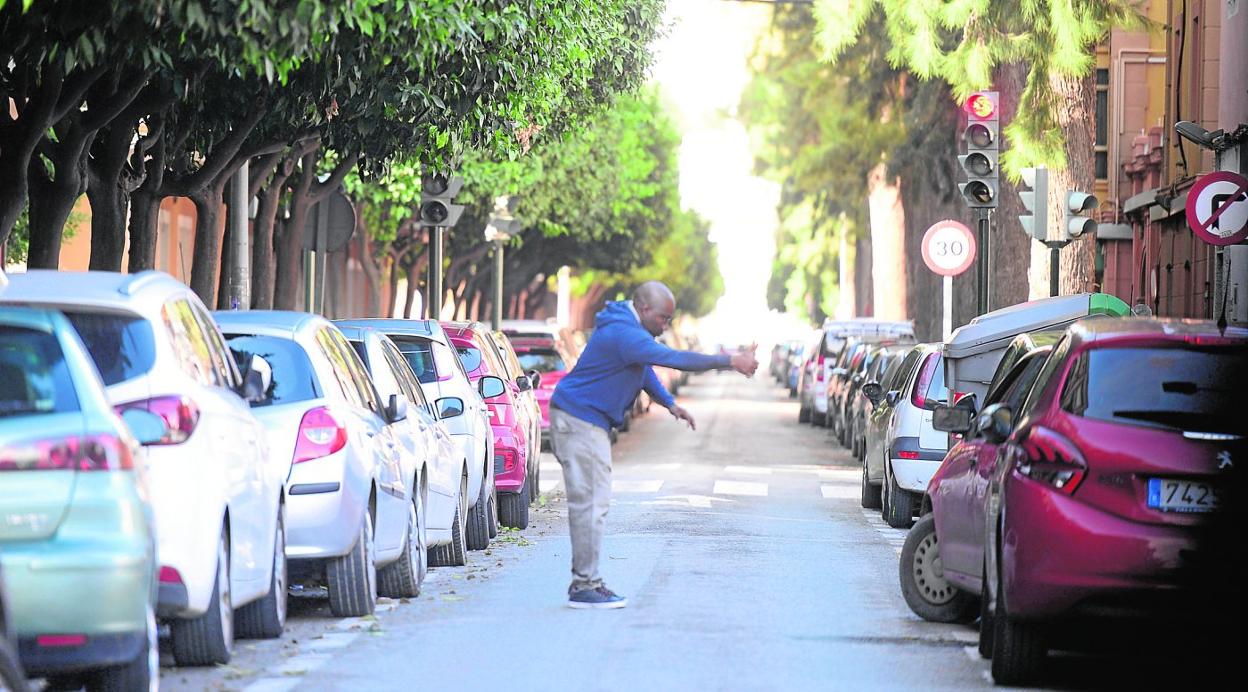 Un gorrilla de la calle Ángel Romero Elorriaga, en el barrio de Vistabella, da instrucciones a un coche. 