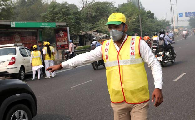 Imagen principal - Restricciones al tráfico en Nueva Delhi (arriba). Ciudadanos con máscaras en la calle para evitar la contaminación. Tradicional quema de rastrojos en India (sobre estas líneas).