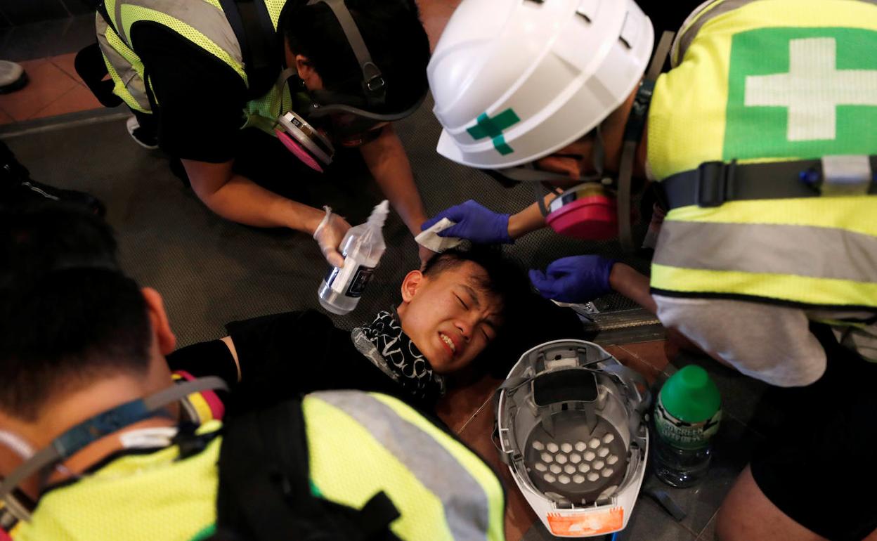 Un manifestante es asistido por un equipo sanitario en Hong Kong durante una nueva jornada de protestas.