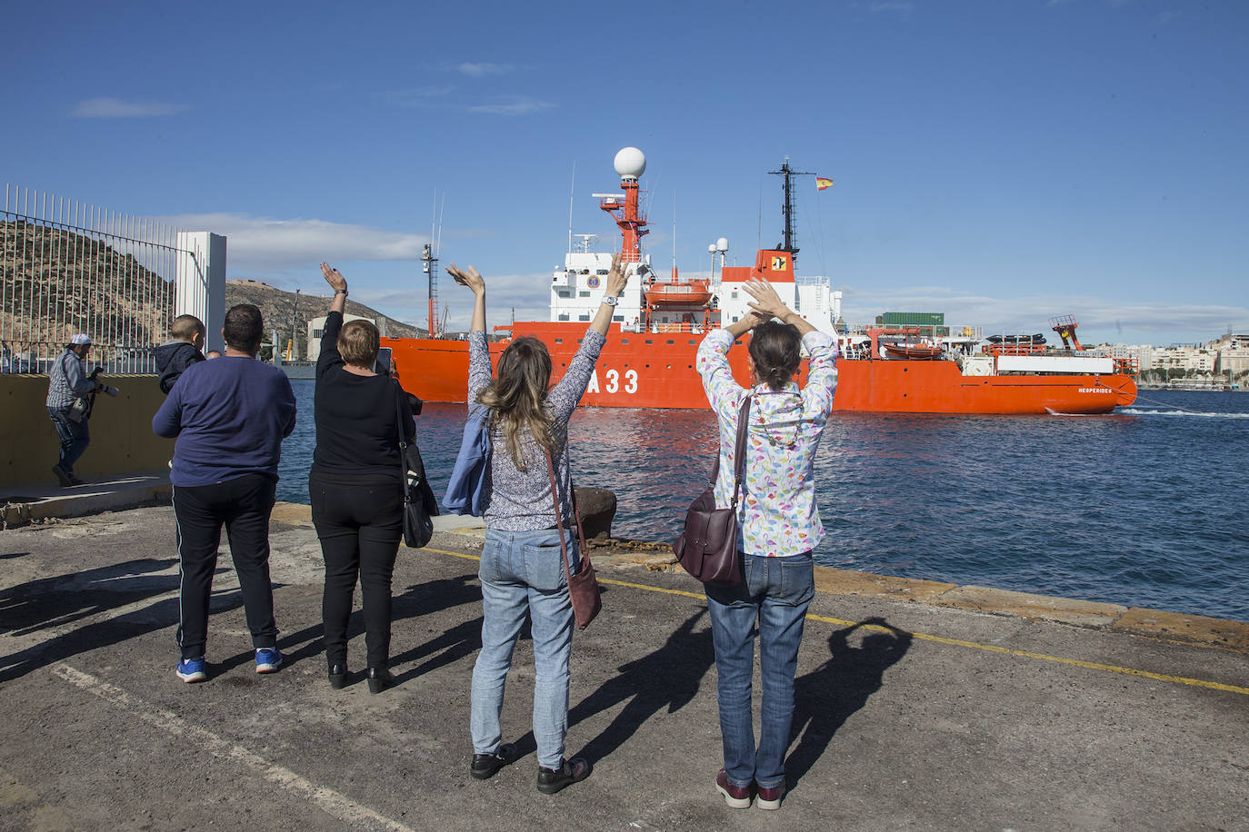 Un joven se despide de su pareja en el muelle de La Curra de Cartagena.