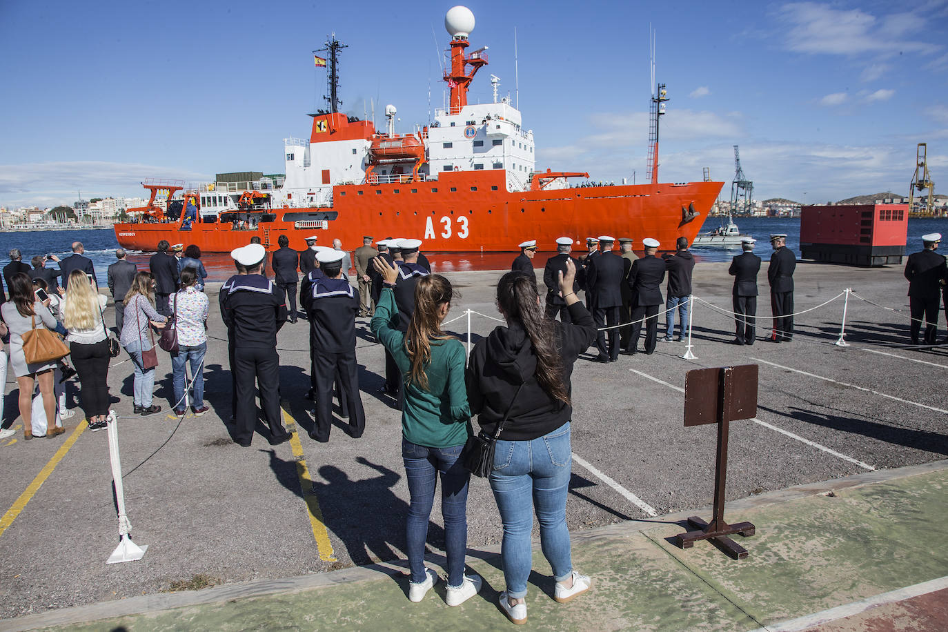 Un joven se despide de su pareja en el muelle de La Curra de Cartagena.