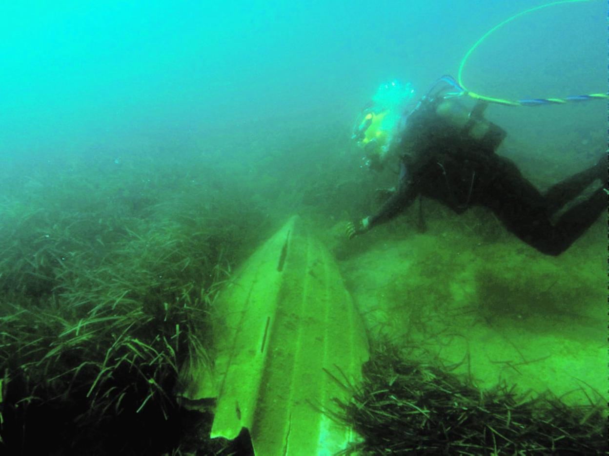 Un buceador examina los restos de una embarcación sobre la pradera de posidonia, en La Azohía. 