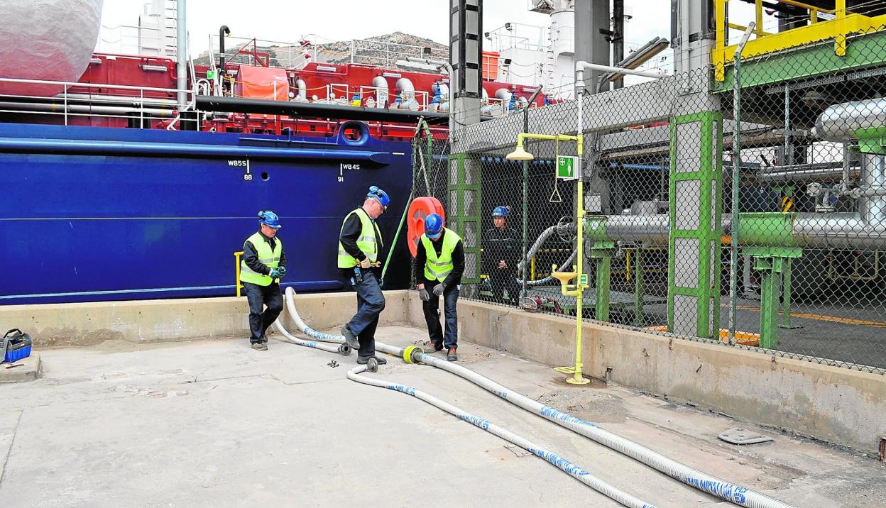 Cuatro trabajadores de la Autoridad Portuaria de Cartagena se preparan para repostar gas natural licuado a un barco. 