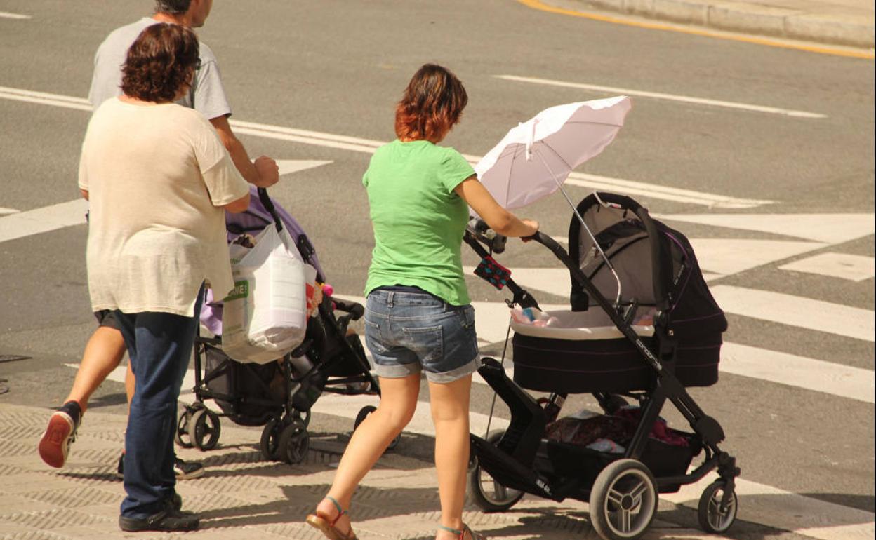 Dos mujeres y un hombre pasean a sus bebés.